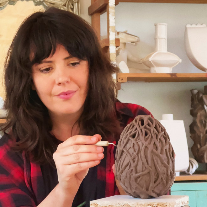 Artist Rozanna Johnson working on a clay sculpture.