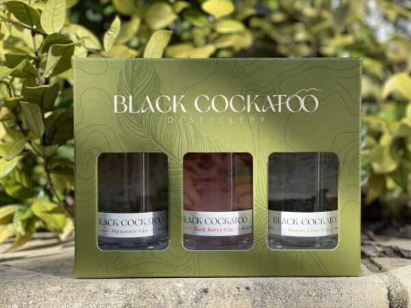 Black Cockatoo Distillery gift pack, showing a collection of three gin flavours, with a garden view behind