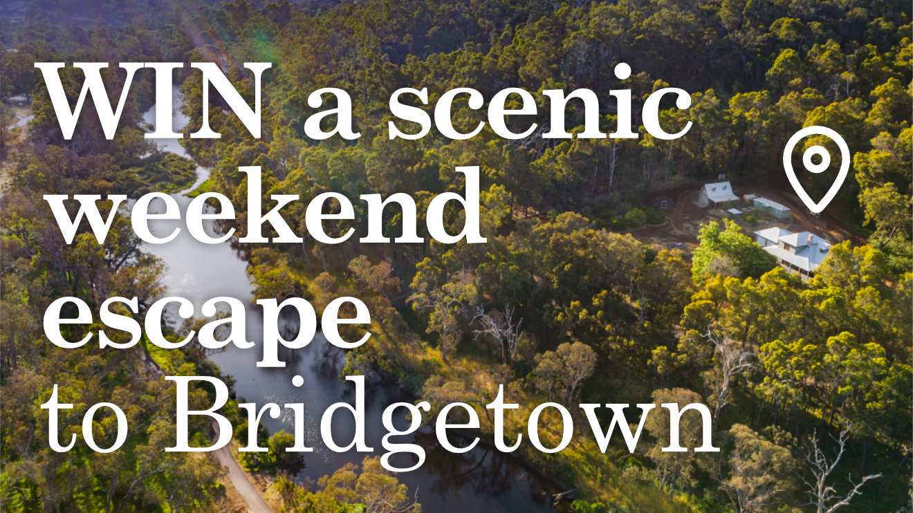 Win a scenic weekend escape to Bridgetown, showing an aerial photo of Stone's Throw Cottage surrounded by native trees and neighbouring a river.