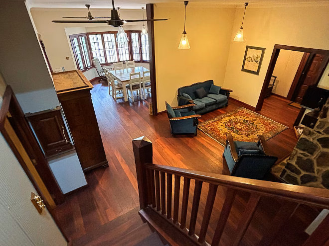 Stone's Throw Cottage in Bridgetown, showing the furnished interior living and dining spaces as seen from the stairs.