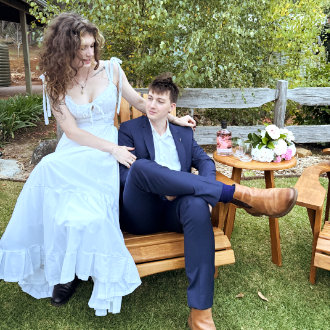 A wedding couple chats while sitting on a wooden deckchair on the Black Cockatoo Distillery Cellar Door lawn.